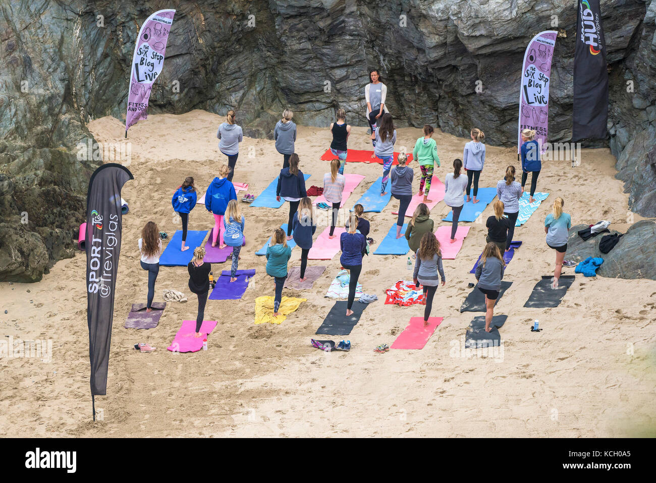 Un womens' gruppo a praticare yoga su una spiaggia - Surf Betty's Festival a womens' festival tenutosi a Newquay emancipazione delle donne attraverso il fitness e surf. Foto Stock
