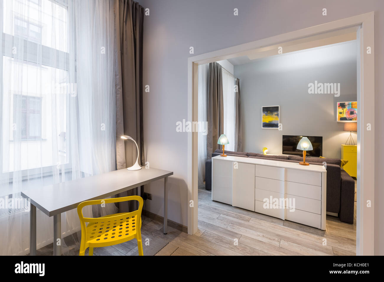 Home interno con semplice scrivania e sedia giallo Foto Stock