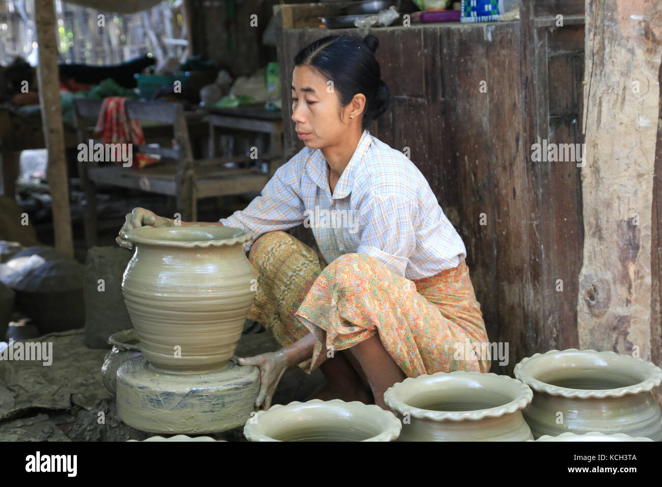 Una donna è di aggiungere un bordo puntinato ad una pentola lei sta lavorando su in Yandabo villaggio sul fiume Irrawaddy in Myanmar (Birmania). Foto Stock