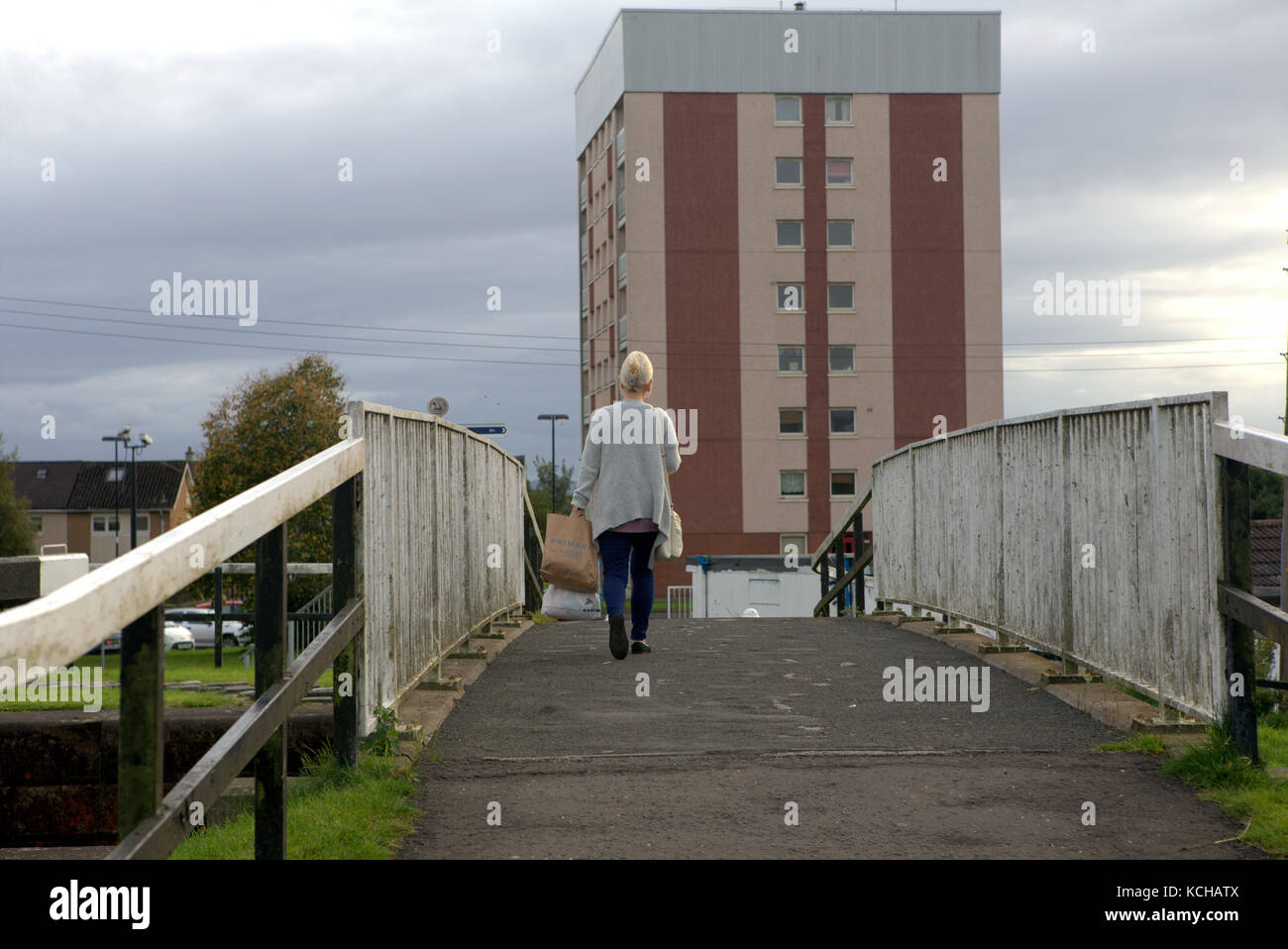 Il ponte pedonale di Kelso Street è a cavallo di Forth e il ponte di attraversamento del canale Clyde, con le sole borse dello shopping, un unico ambiente femminile di colore bianco Foto Stock