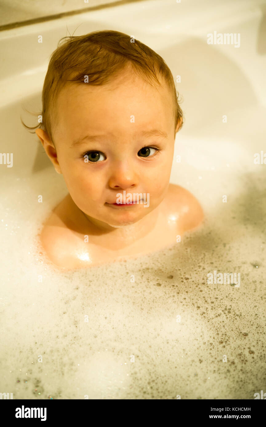Un anno vecchio ragazzo giocando in una vasca da bagno Foto Stock
