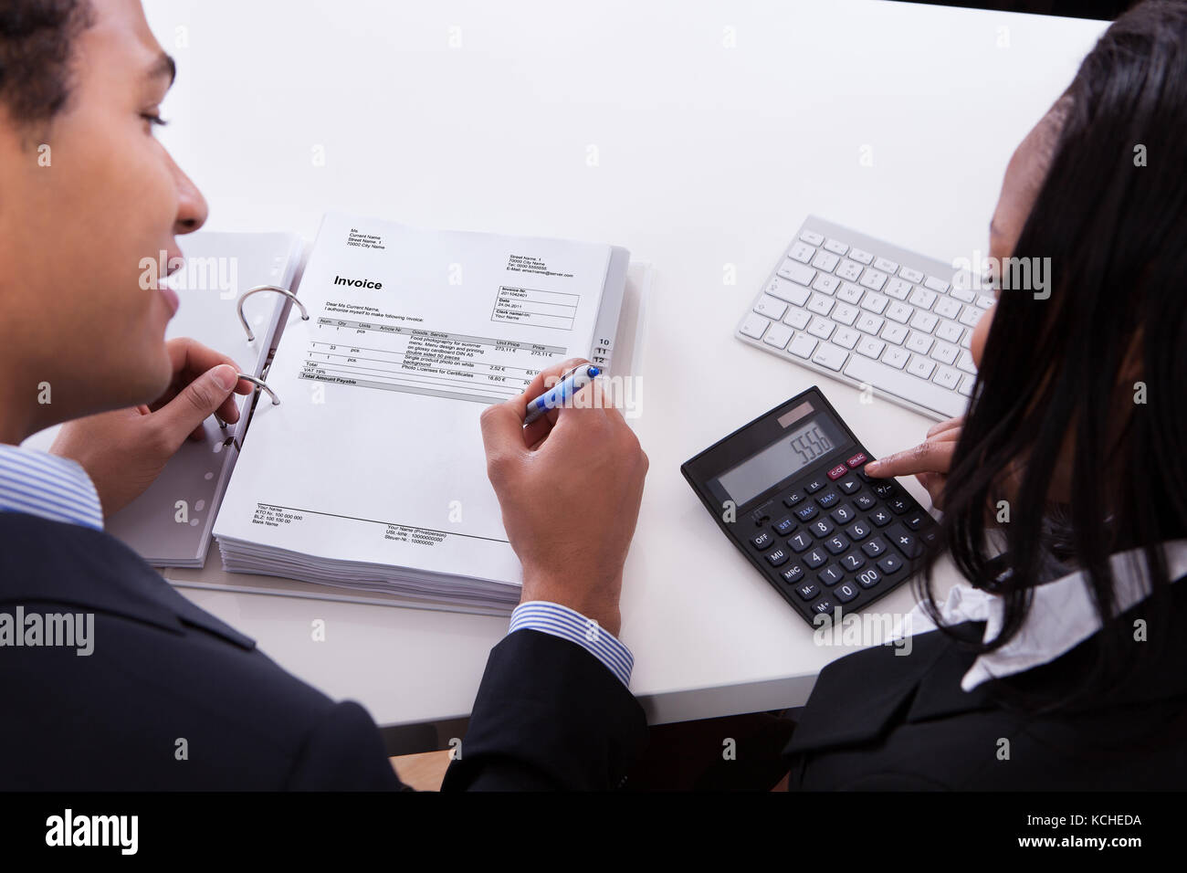 Due uomini di affari che il calcolo di finanziare insieme in ufficio Foto Stock