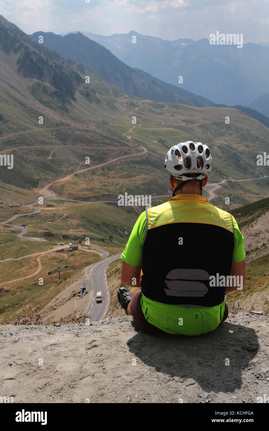 TOURMALET, FRANCIA, 16 luglio 2015 : Un ciclista riposa al passo, guardando il paesaggio. Col du Tourmalet è il più alto passo lastricato della F Foto Stock