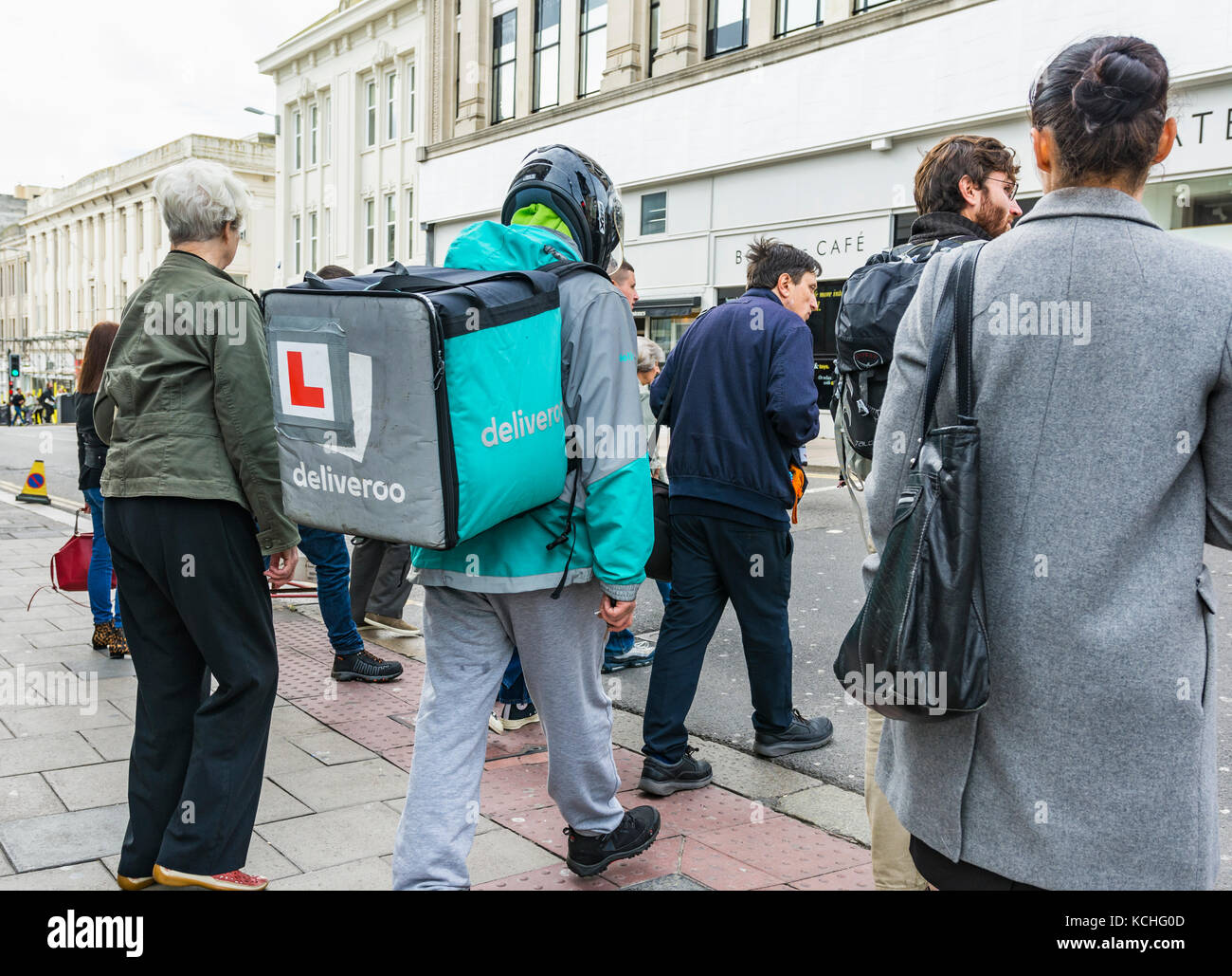 Dipendente Deliveroo sul cibo con un zaino Deliveroo in Brighton, East Sussex, Inghilterra, Regno Unito. Foto Stock