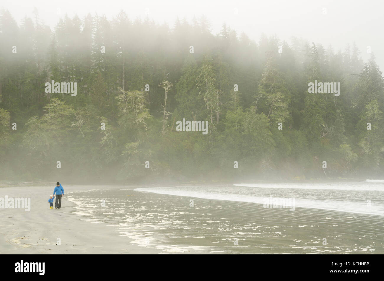 Un ragazzo e la sua mamma le escursioni su una spiaggia di nebbia a Pachena Bay, l'isola di Vancouver, British Columbia Foto Stock