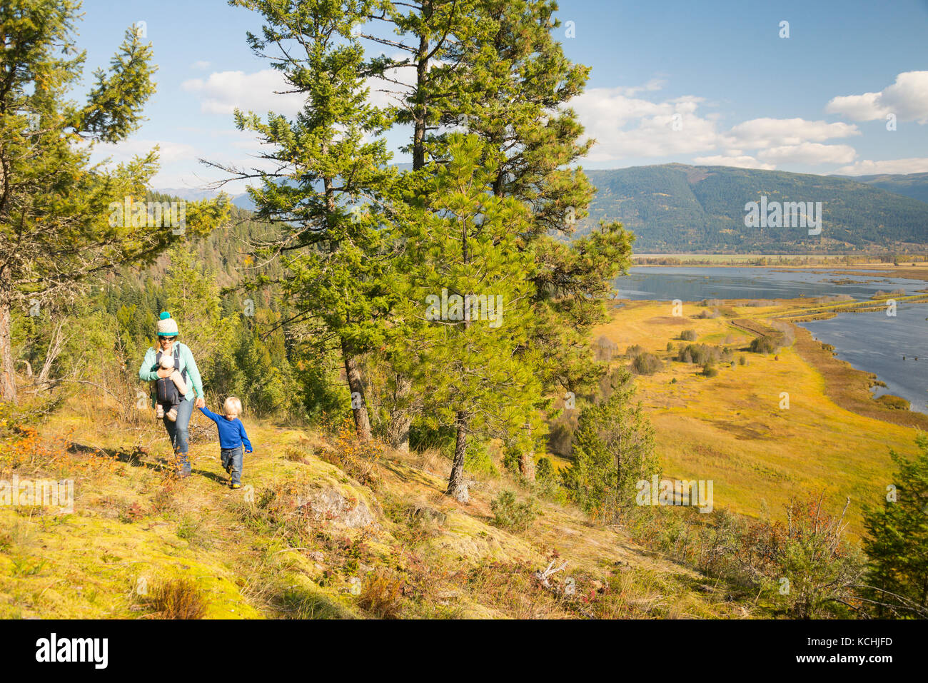 Una donna escursioni con i suoi due bambini al di sopra della valle di Creston zone umide, British Columbia Foto Stock