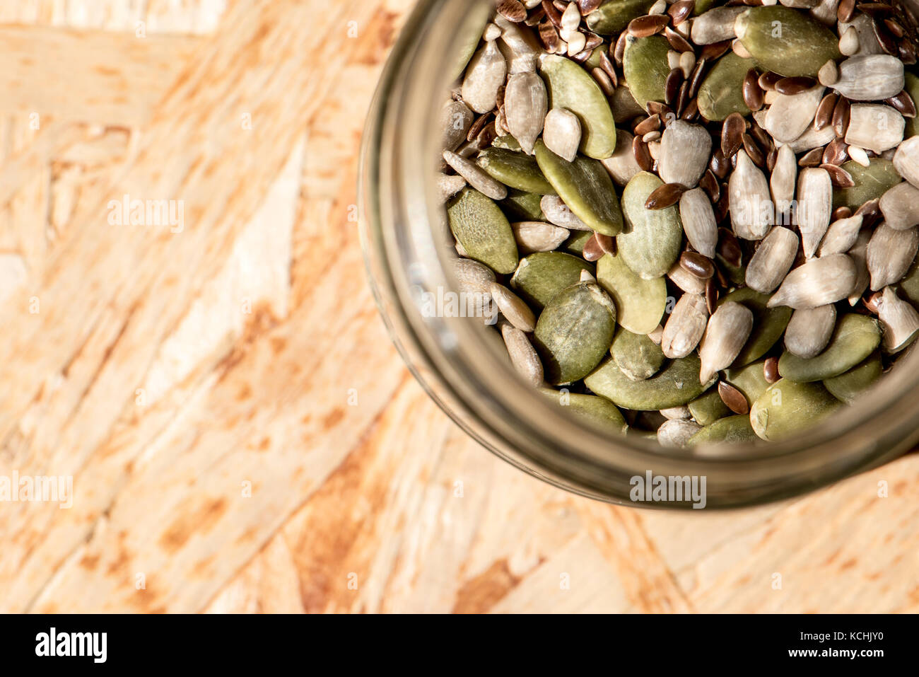 Mason vaso pieno di semi, sano cibo crudo, mix di lino, di sesamo, di zucca e semi di girasole Foto Stock