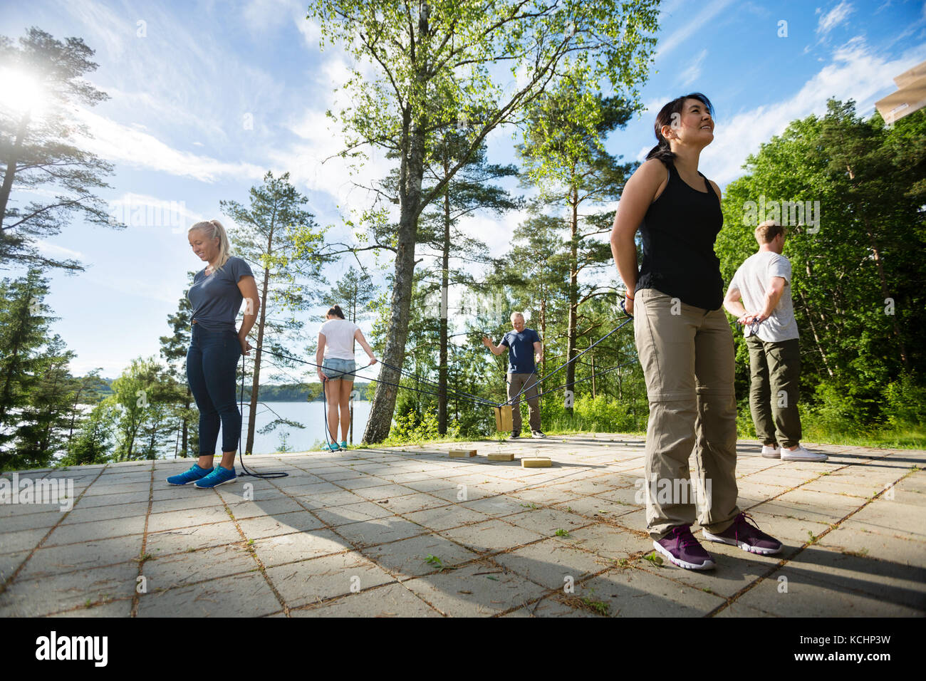 Lunghezza completa di maschio e femmina amici in piedi di fronte ad ogni altro durante la riproduzione con blocchi di legno su un patio in foresta Foto Stock