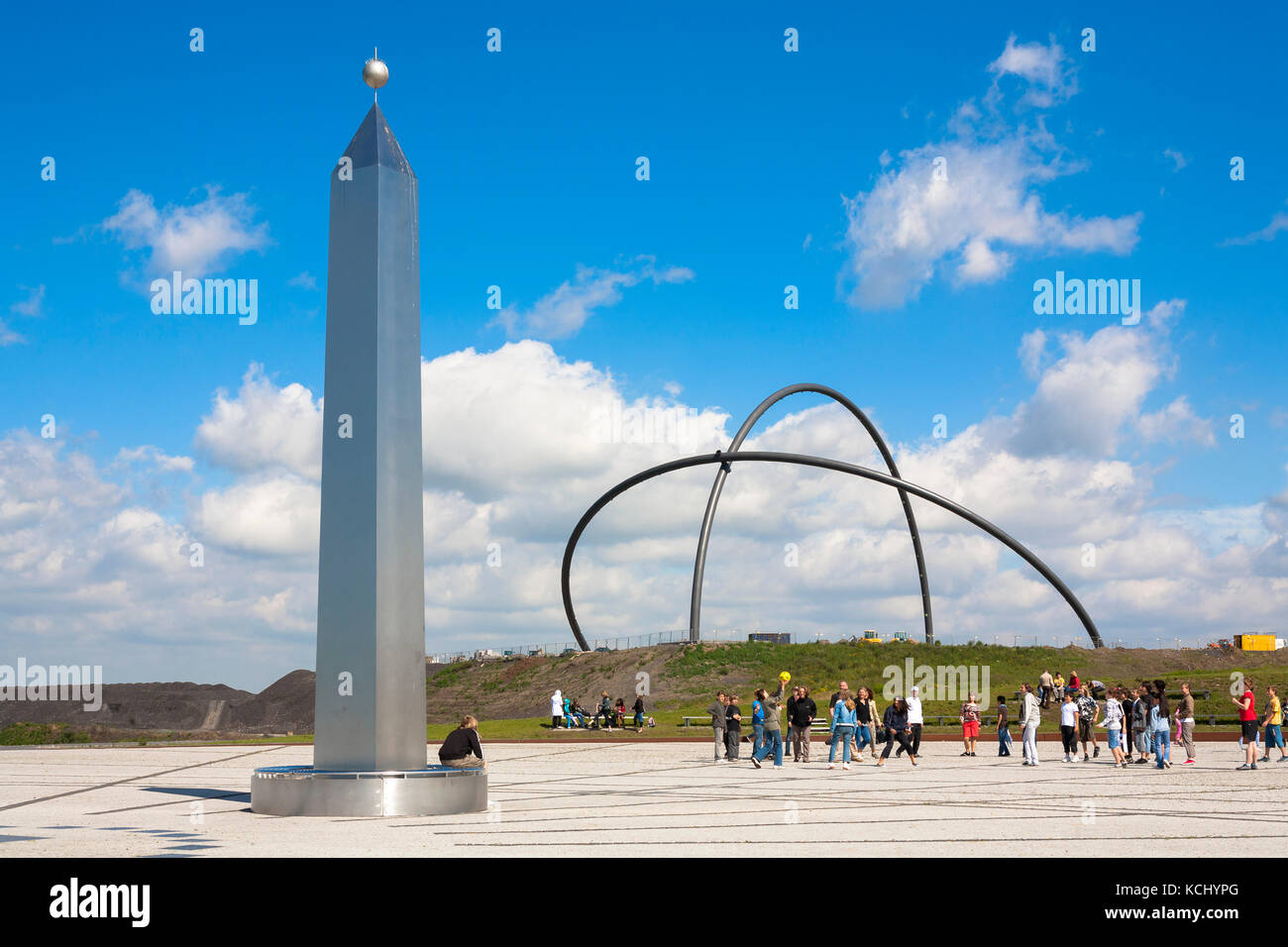 Germania, zona Ruhr, Herten, obelisco sul cumulo Hoeward (l'obelisco è l'indicatore di un grande quadrante di sund) dietro di esso gli archi di 50 metri di altezza del Foto Stock