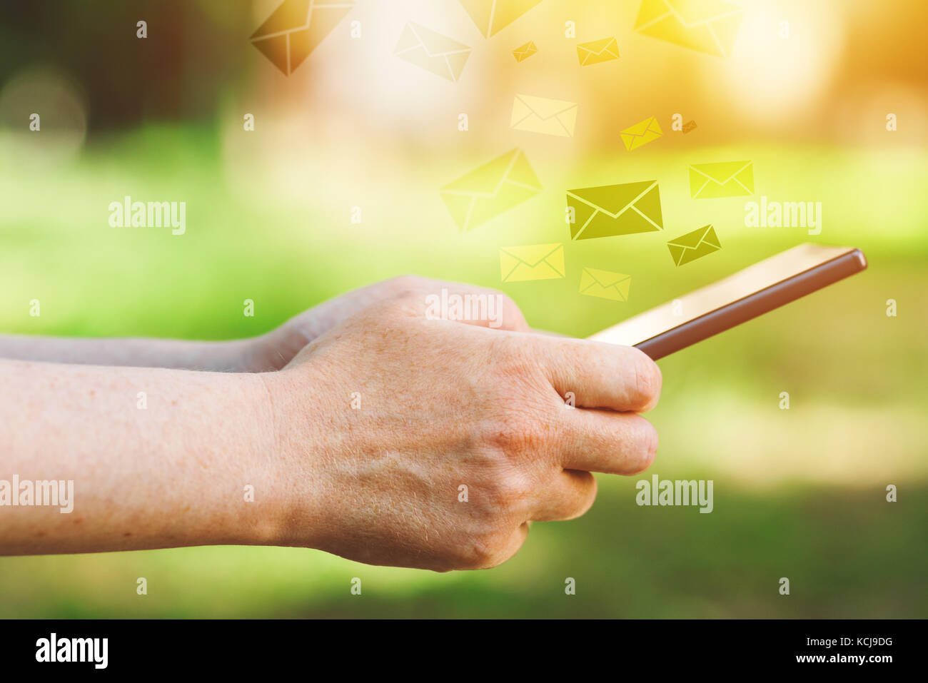 Telefono cellulare il concetto di comunicazione con mani femminili utilizza lo smartphone app e le buste come l'e-mail in uscita o i messaggi di testo Foto Stock