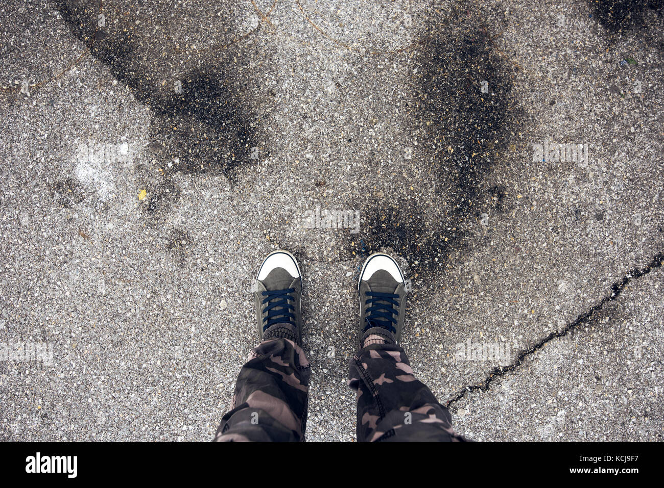 Giovane free avventuroso uomo in piedi sulla strada, calcestruzzo passaggio pedonale come spazio di copia per i viaggi avventura e concetto di libertà Foto Stock