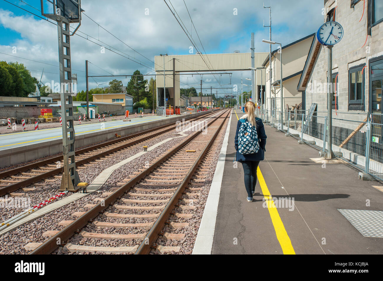 Ragazza bionda sta in piedi in una stazione di gare di steinfort e in attesa per il suo treno, Lussemburgo Foto Stock