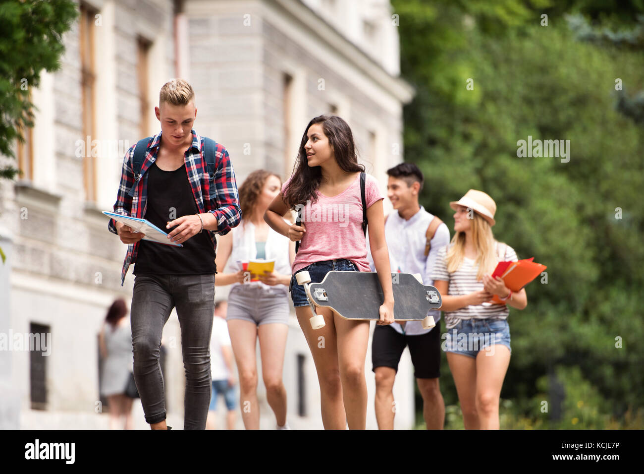 Gruppo di attraente studenti adolescenti a piedi università. Foto Stock