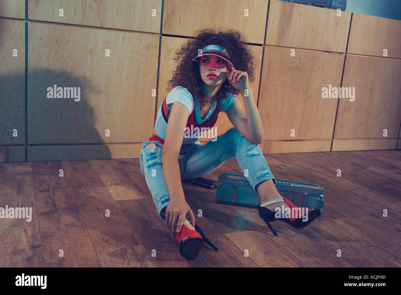 Moda Donna con boombox seduto sul pavimento Foto Stock