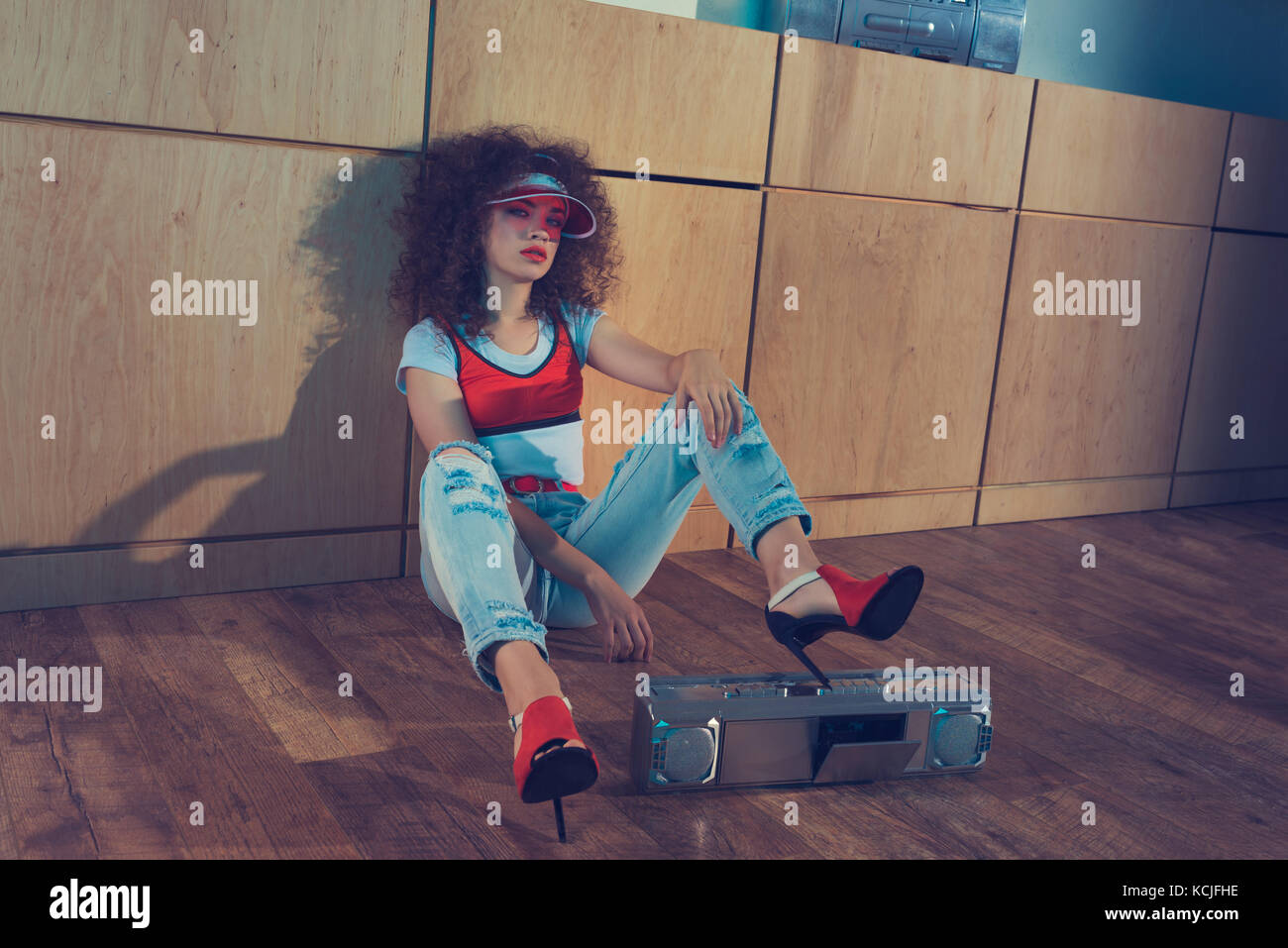 Moda Donna con boombox seduto sul pavimento Foto Stock