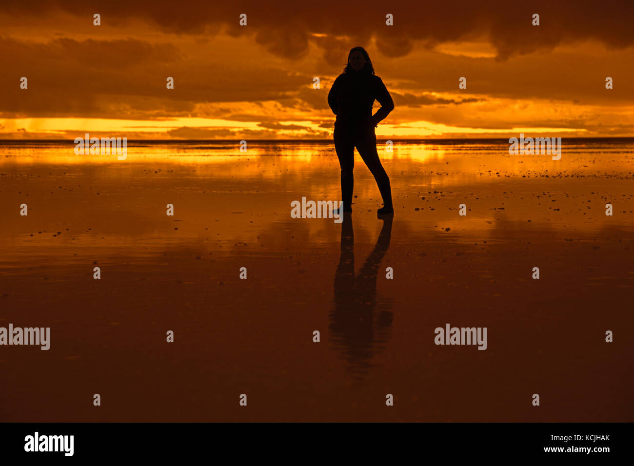 Silhouette di turista in posa sul Salar de Uyuni / salar de tunupa al tramonto, il più grande del mondo di distesa di sale, Daniel Campos provincia in Potosi, Bolivia Foto Stock