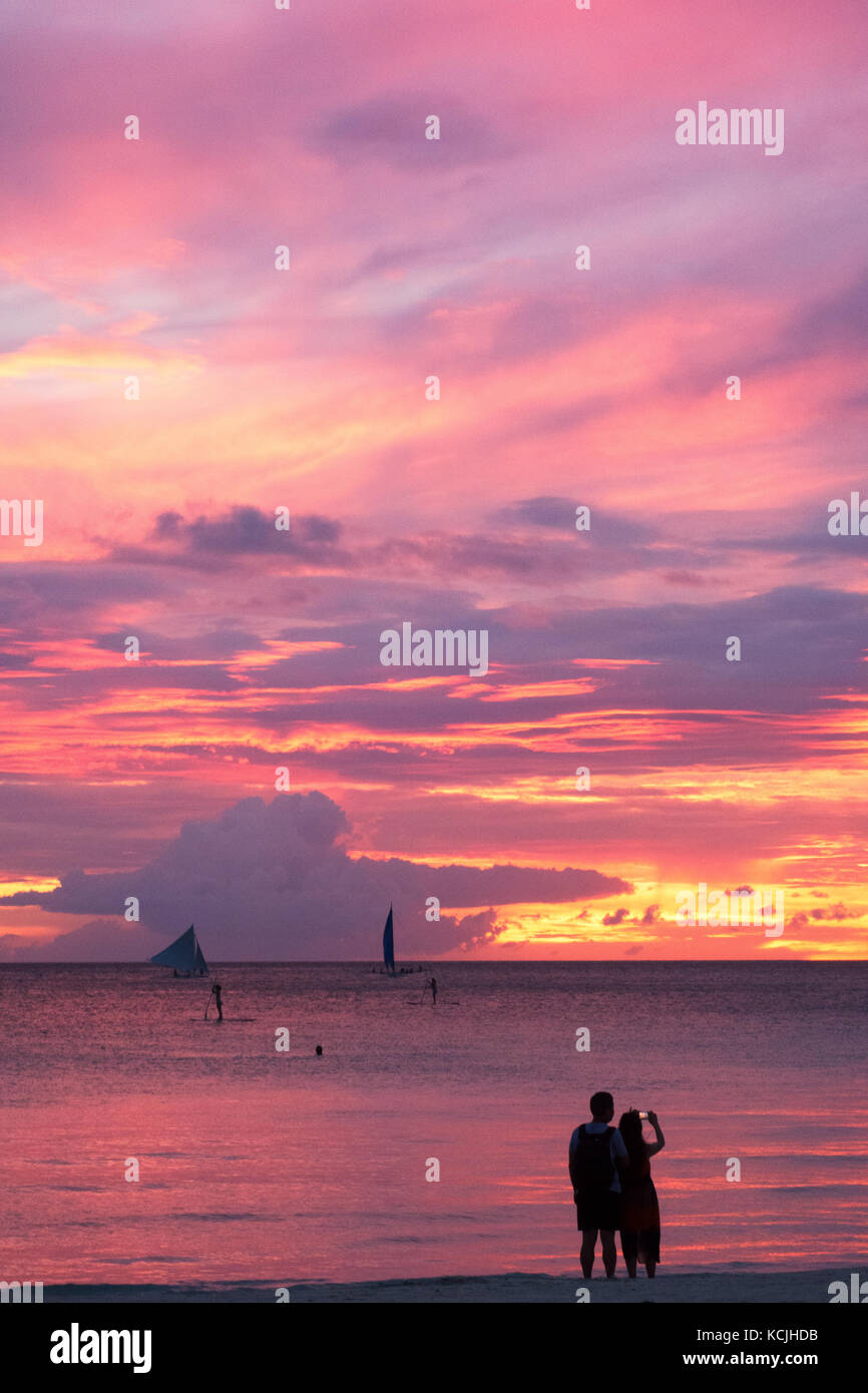 Filippine tramonto - una coppia che guarda il tramonto a Boracay spiaggia, Boracay, Filippine Asia Foto Stock