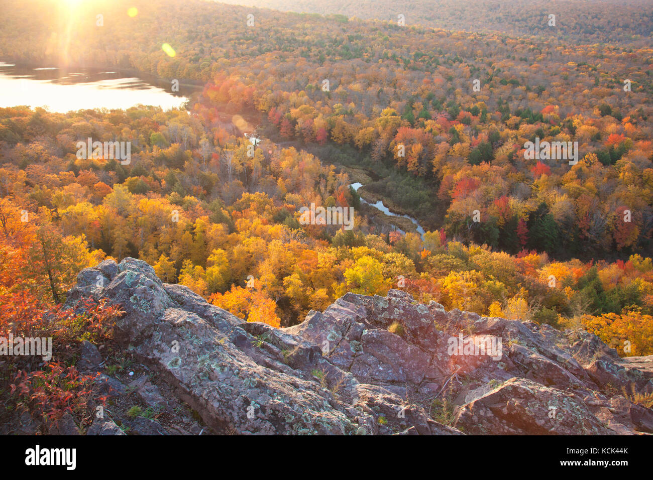 In autunno gli alberi in piena di colore con la parete rocciosa a bordo lago di nuvole michigan. prese a sunrise. Foto Stock