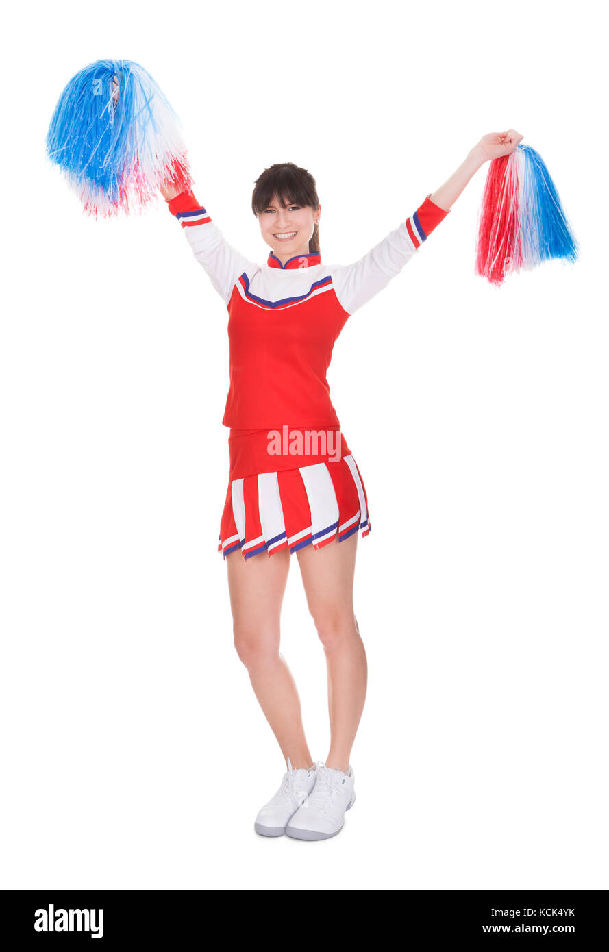 Felice cheerleader holding pom-pom su sfondo bianco Foto Stock