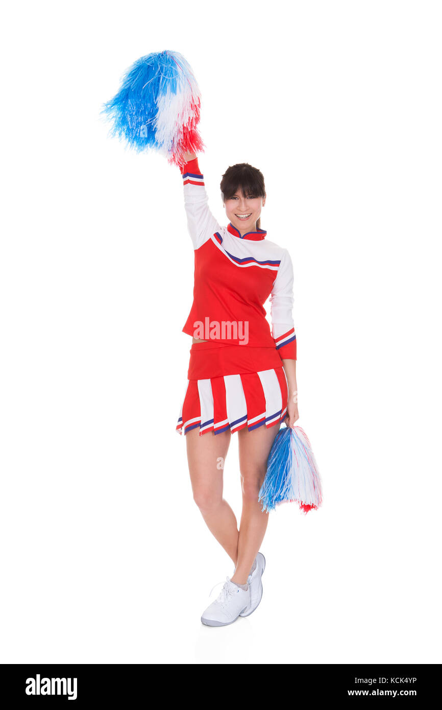 Felice cheerleader holding pom-pom su sfondo bianco Foto Stock