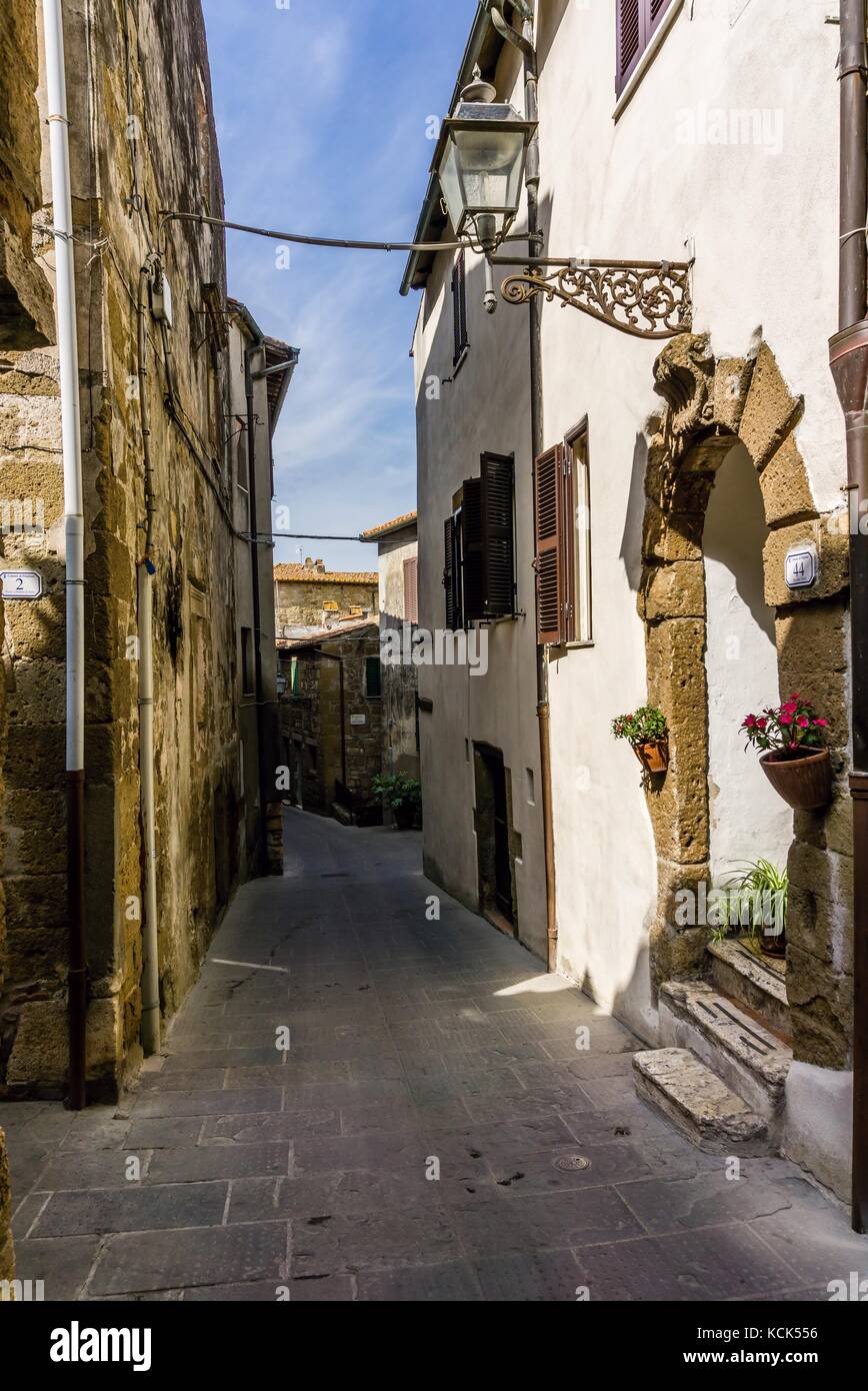 Foto verticale con vista in stretta strada antica in pitigliano città storica. città si trova in Italia Toscana. old stone road è tra house Foto Stock