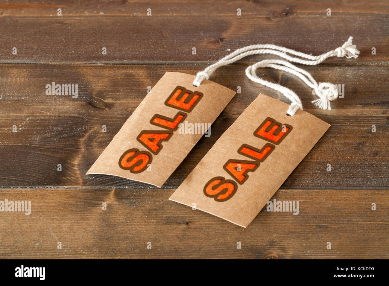 Vendita di due etichette su un tavolo di legno. lettere rosse e la stringa sulle etichette Foto Stock
