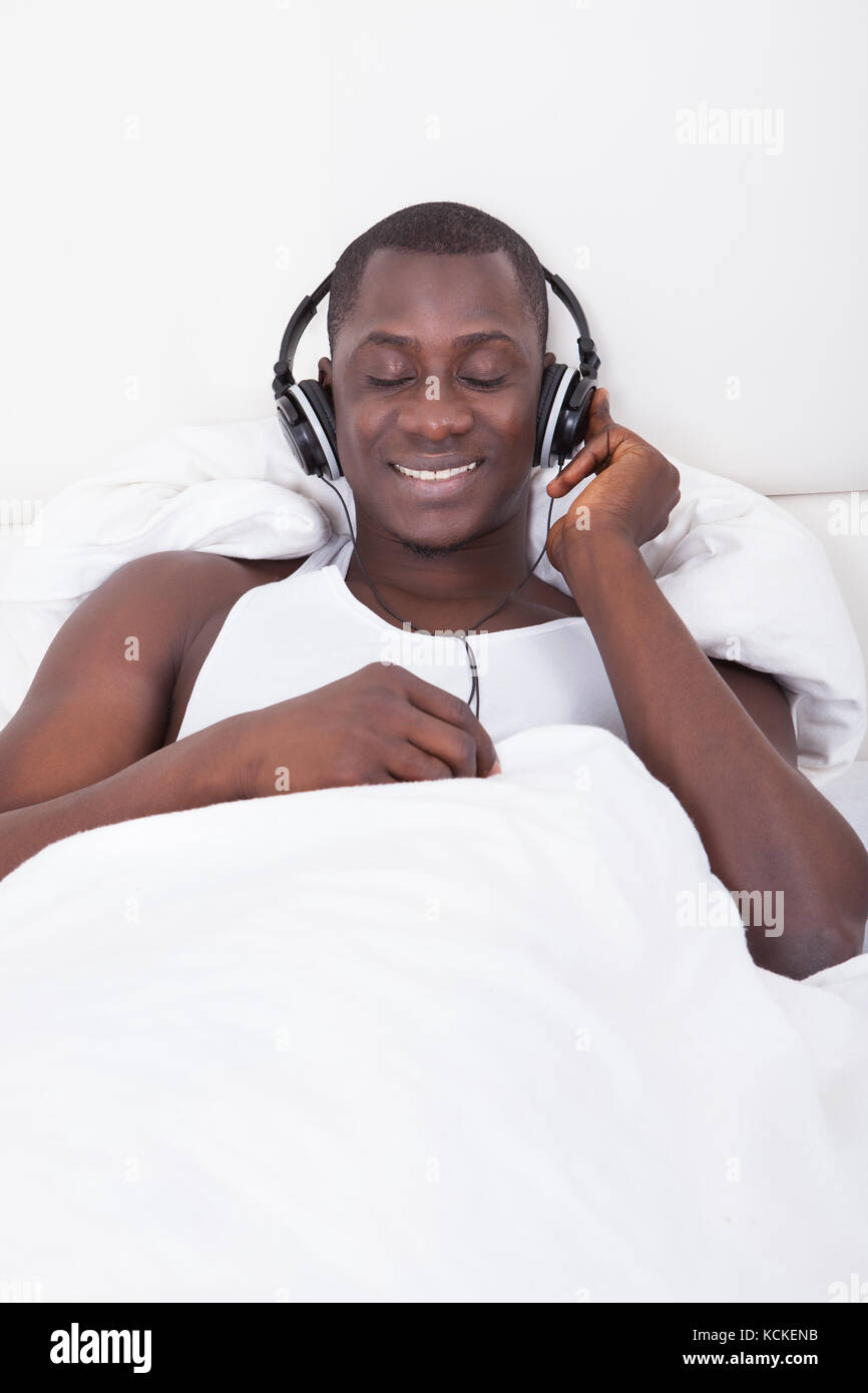 L'uomo africano ascoltando la musica attraverso le cuffie Foto Stock