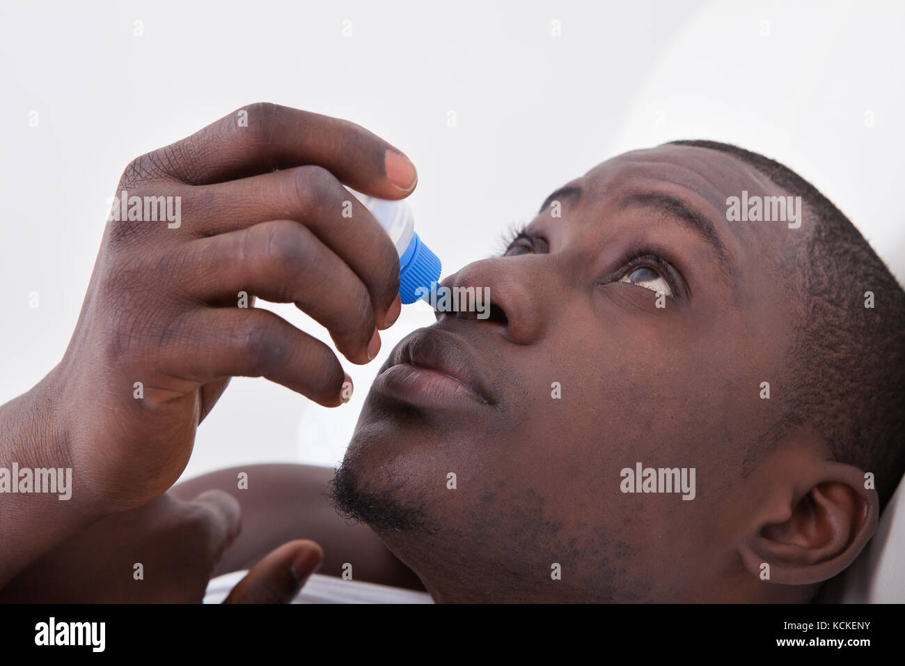 Close-up di uomo africano mediante spray nasale Foto Stock