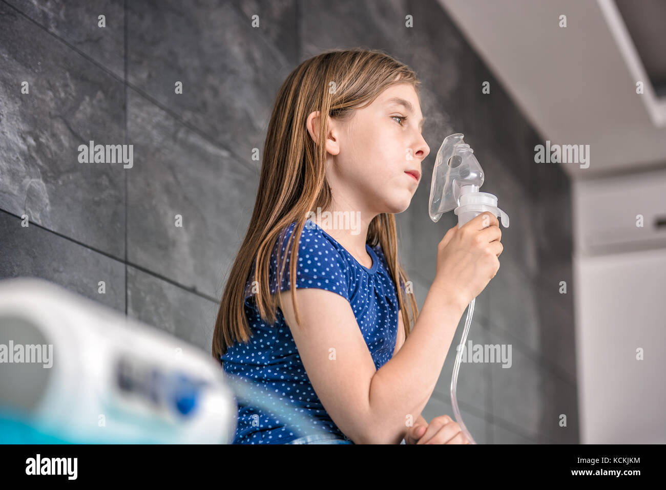 Bambina avente un medico di trattamento di inalazione con un nebulizzatore in ospedale Foto Stock