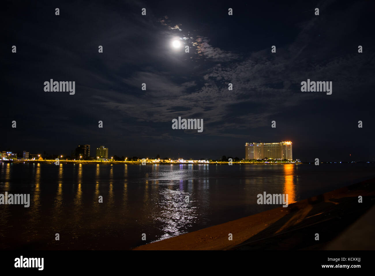 Paesaggio notturno del fiume Tonle Sap e la sua conflux con il Fiume Mekong. Hotel di lusso in distanza, moonlight riflettenti, Sisowath Quay, Cambogia Foto Stock