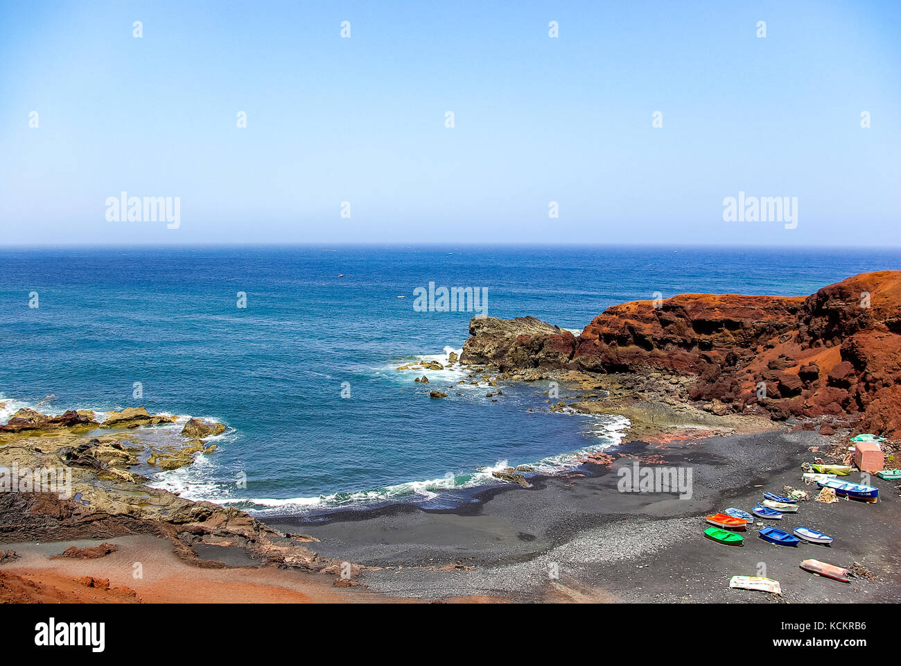 Barche da pesca e lava nera spiaggia di El golfo, lanzarote, Spagna. Foto Stock