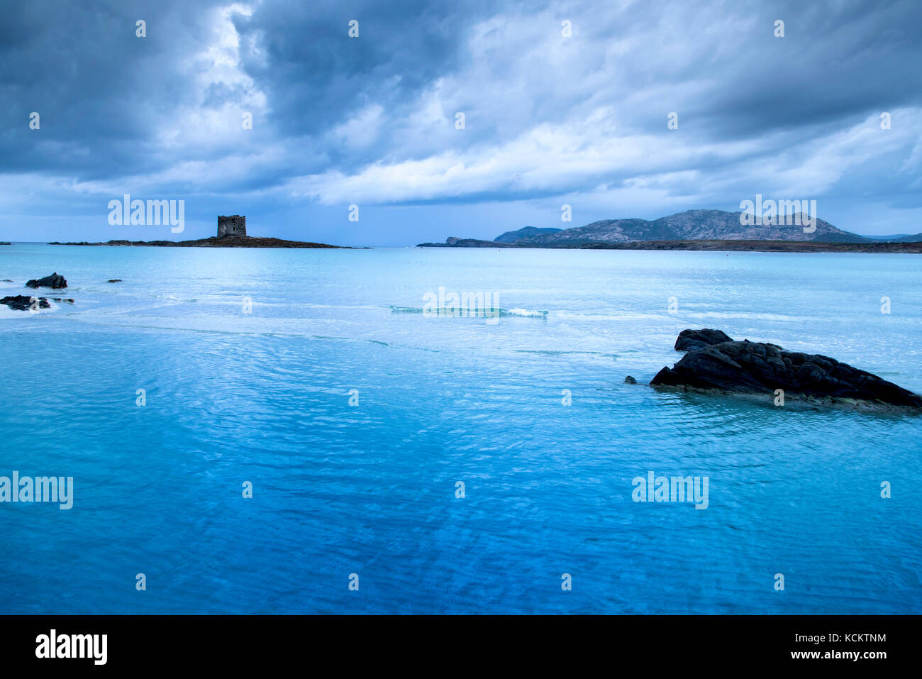 Vista sulla spiaggia della Pelosa in Sardegna, con la torre della Pelosa e l'isola piana sullo sfondo Foto Stock