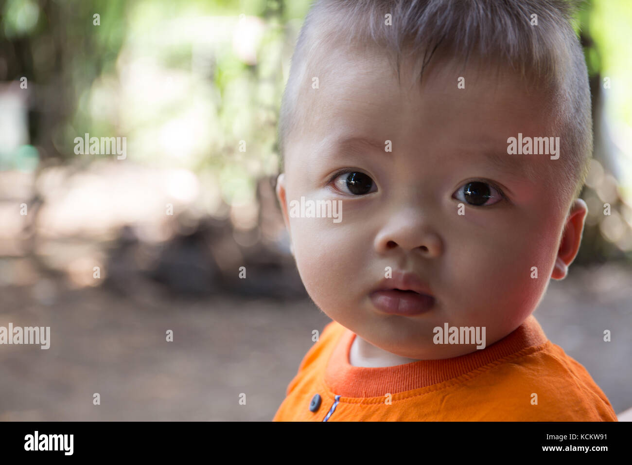 Carino baby boy indossando t-shirt, closeup kid ritratto con sfondo sfocato. Foto Stock