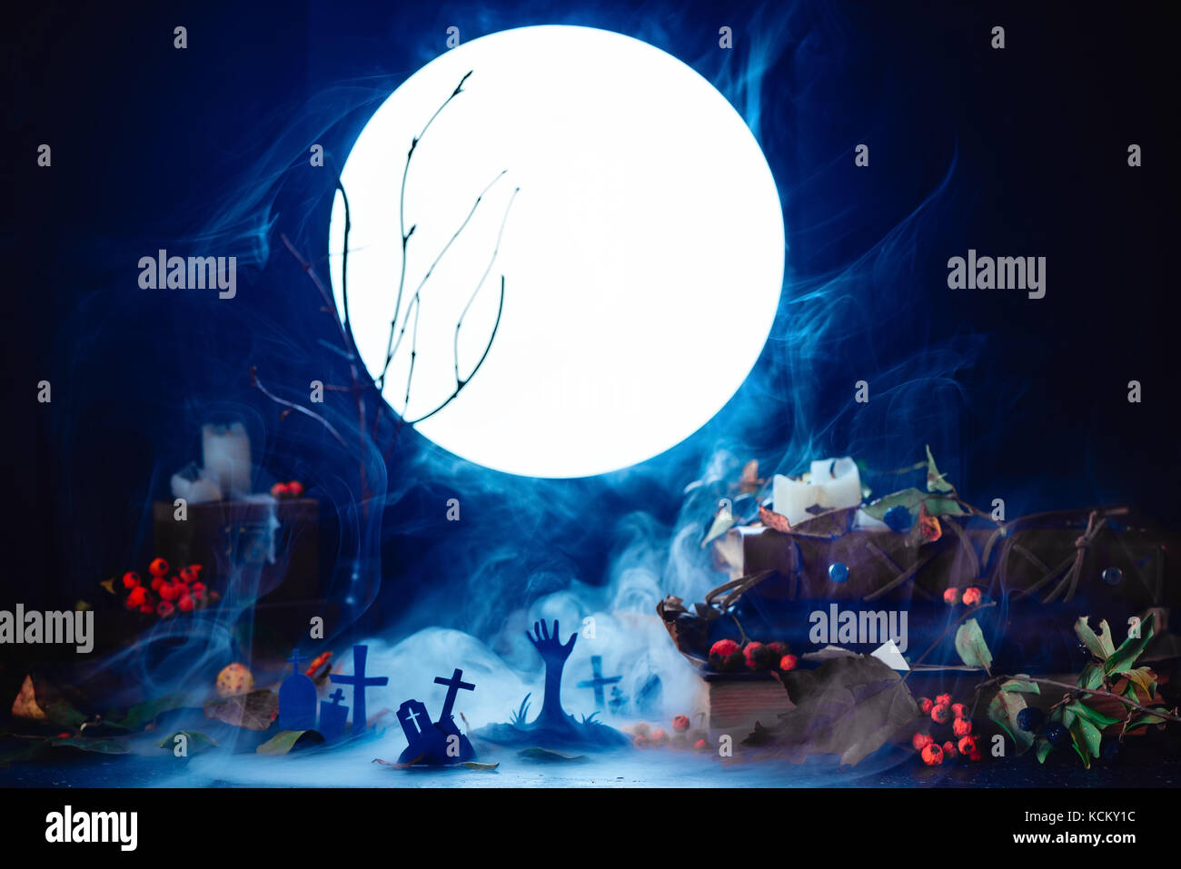 Cimitero con rising zombie sagome in luce della luna piena. halloween concettuale ancora in vita con fumo, rami secchi, candele e Magia Equipaggiamento. Foto Stock