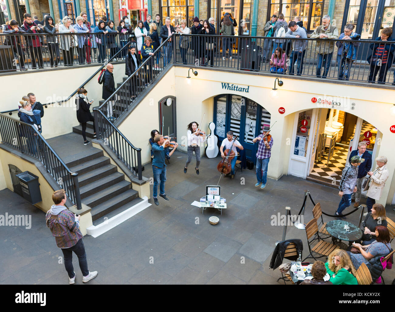 Una string band divertente acquirenti nel mercato di Covent Garden, Londra, Inghilterra, Regno Unito Foto Stock