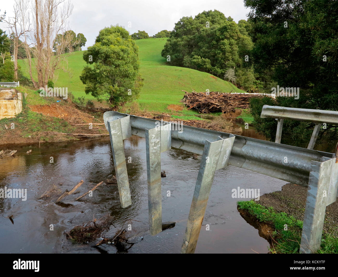 Ponte sul fiume Flowerdale danneggiato dalle alluvioni, lavato via nel vicino pascolo sotto il peso di detriti. Lapoinya, Tasmania, Australia Foto Stock