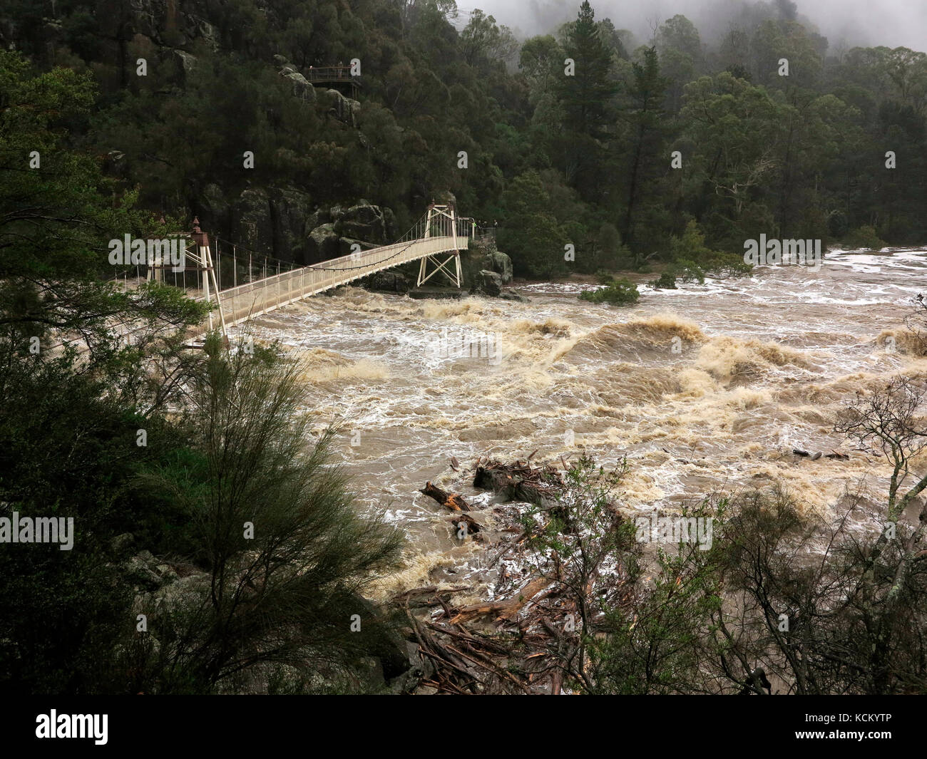Sud del fiume Esk in alluvione e il ponte sospeso al primo bacino quasi sotto l'acqua. Cataract Gorge, Launceston, Tasmania, Australia Foto Stock