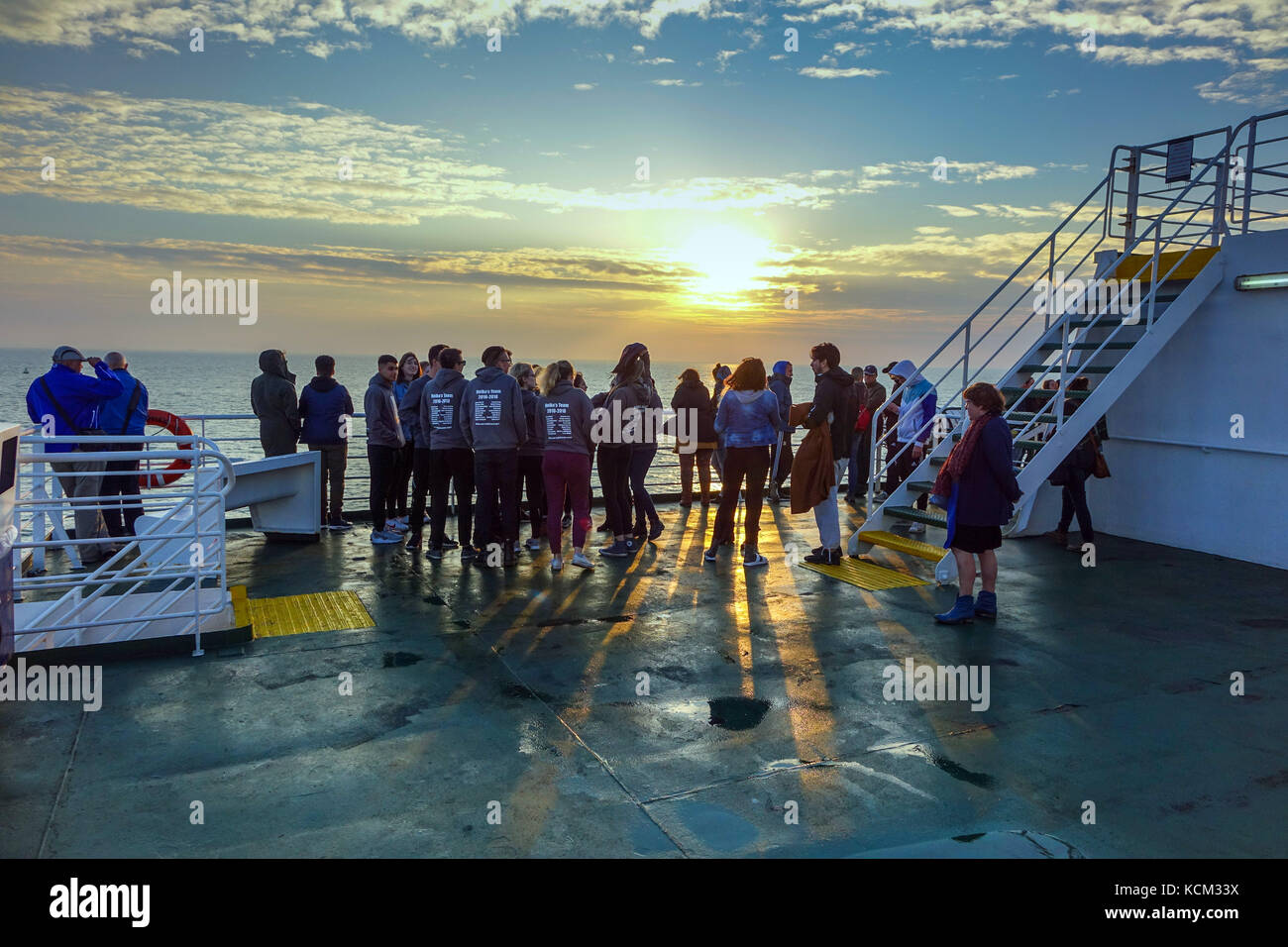 La Folla di studenti al tramonto sul Mare del Nord in traghetto Foto Stock