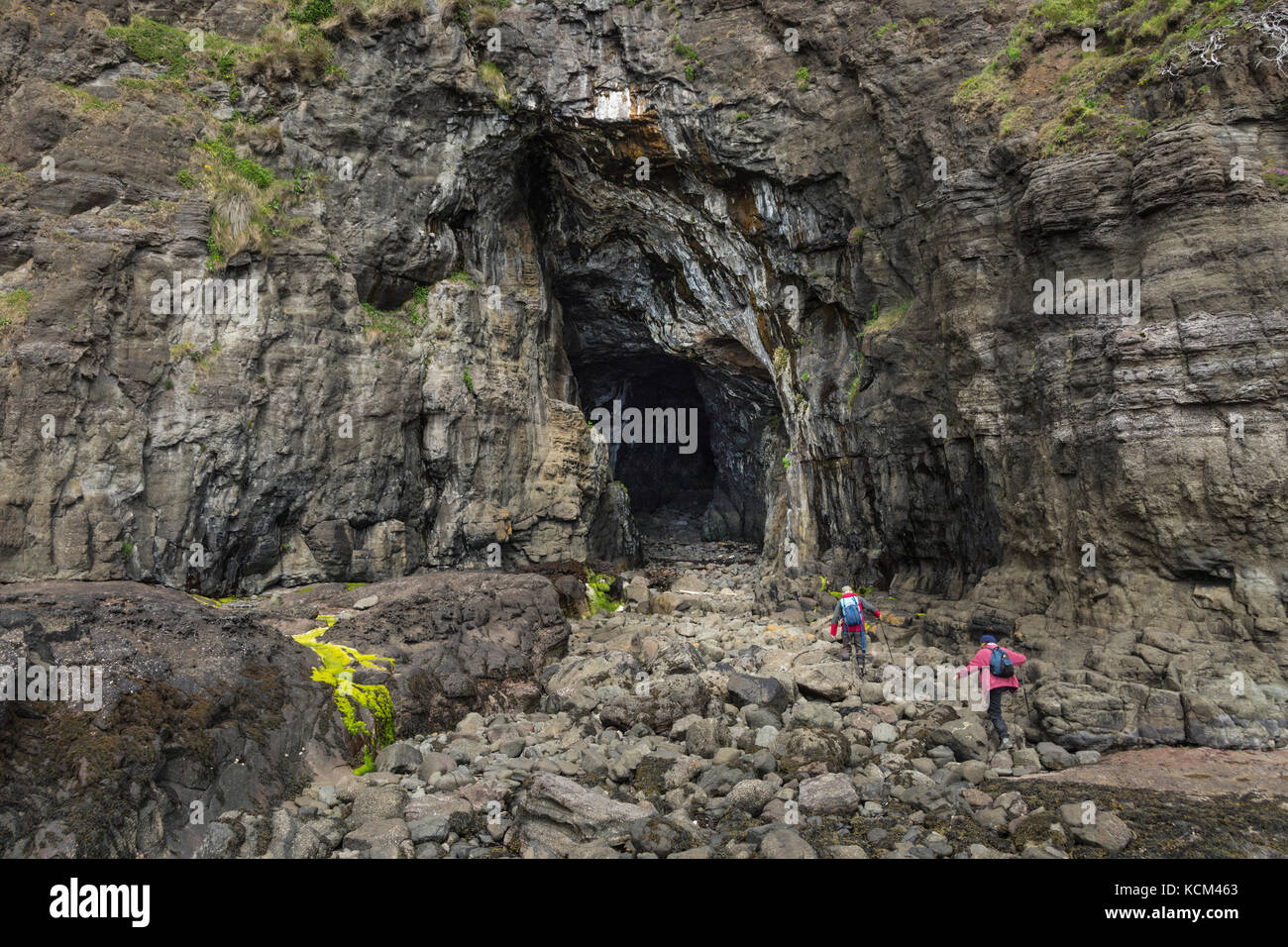 Passeggiate all'ingresso della Cathedral Cave, vicino a Galmisdale sull'Isola di Eigg, Scozia, Regno Unito Foto Stock