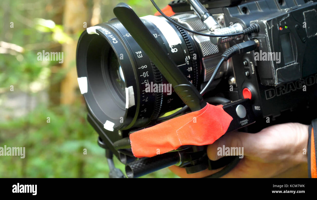 Uomo con una telecamera le riprese di un film nella foresta. telecamera  costosi per i filmati nel bosco Foto stock - Alamy