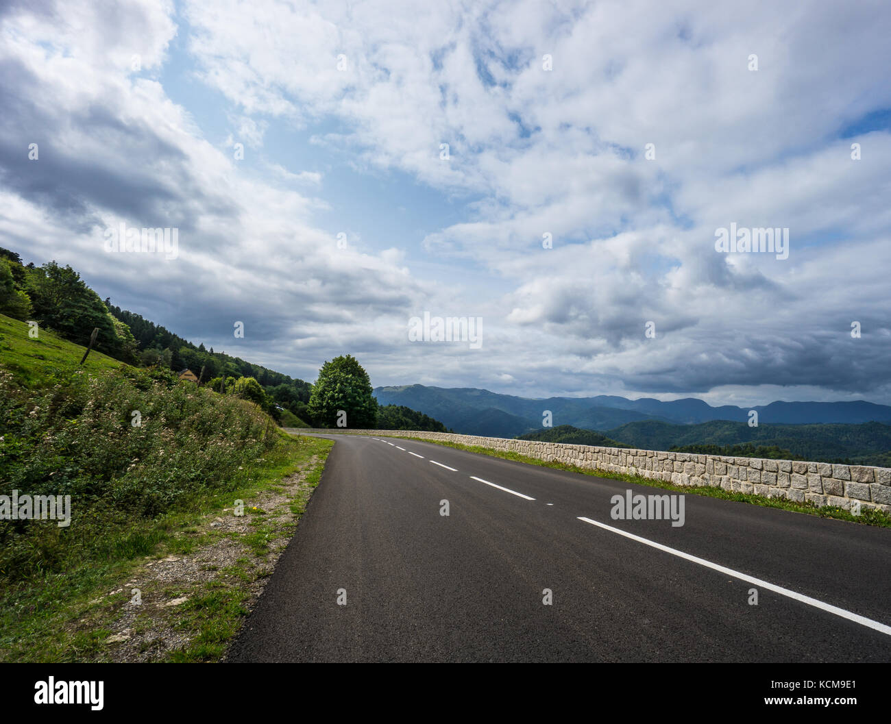 Francia - Route de cretes svolta a sinistra con incredibili montagne boscose in background Foto Stock