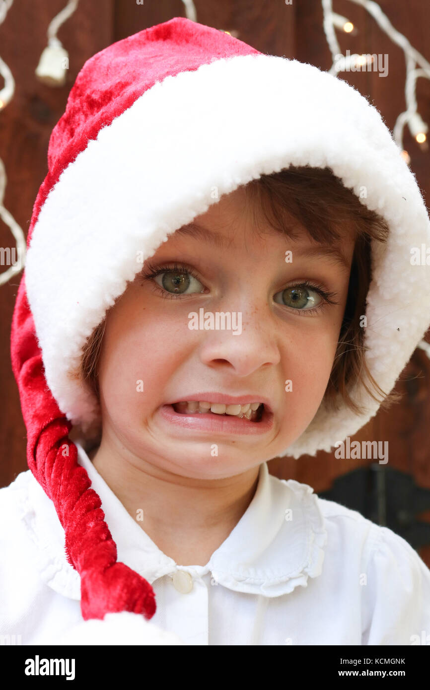 Ritratto di una giovane ragazza con un cappello da Babbo Natale cercando sottolineato Foto Stock