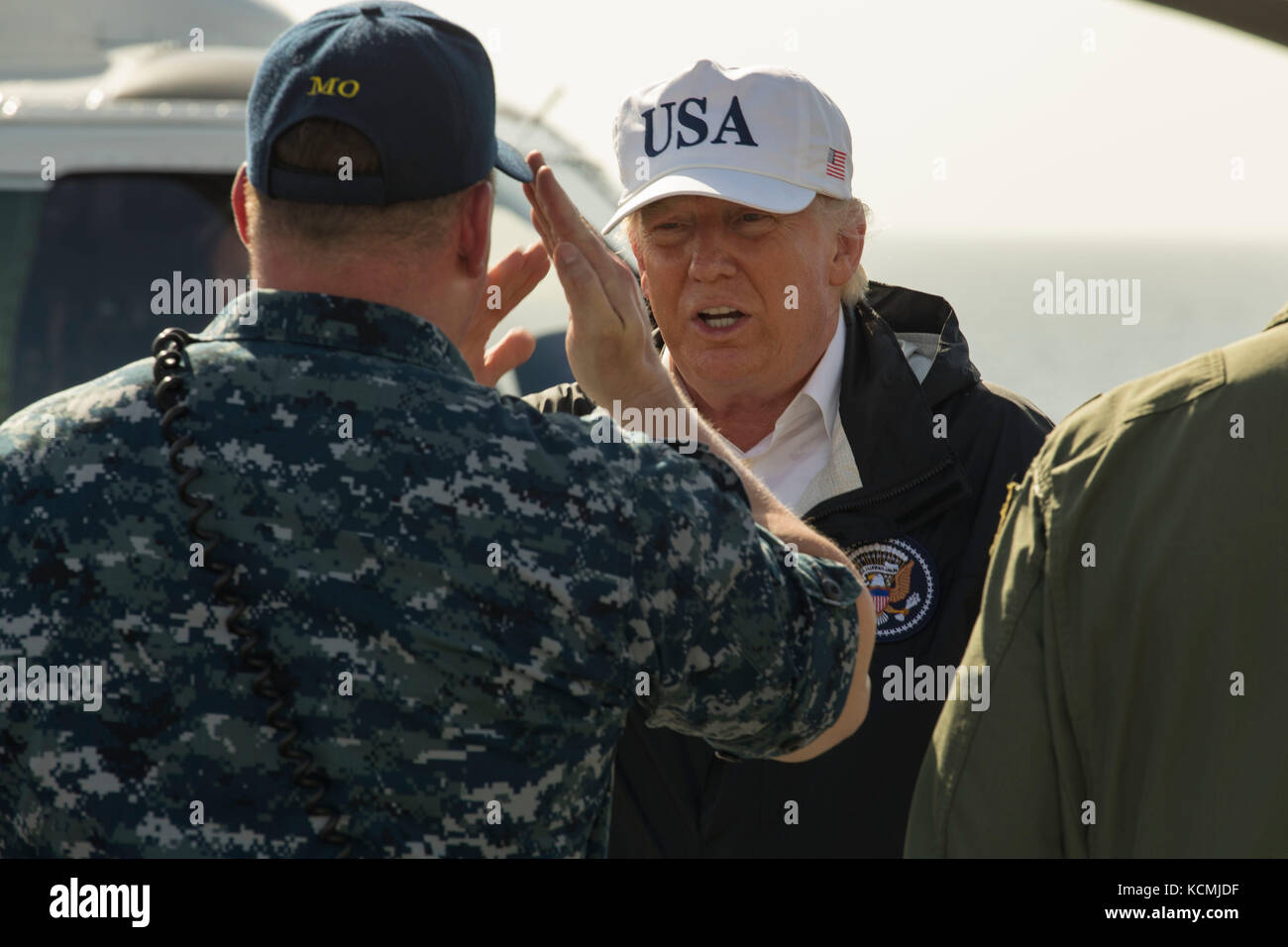 Presidente Donald Trump restituisce un saluto da Lt. La Cmdr. Todd Dupree sul ponte di volo Foto Stock