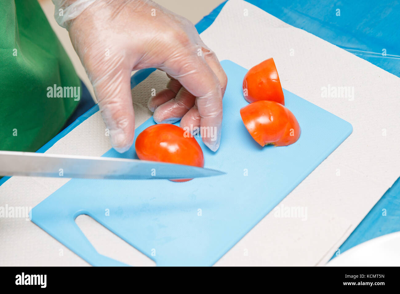 La mano dello chef e il Coltello per affettare o taglio di pomodori rossi Foto Stock