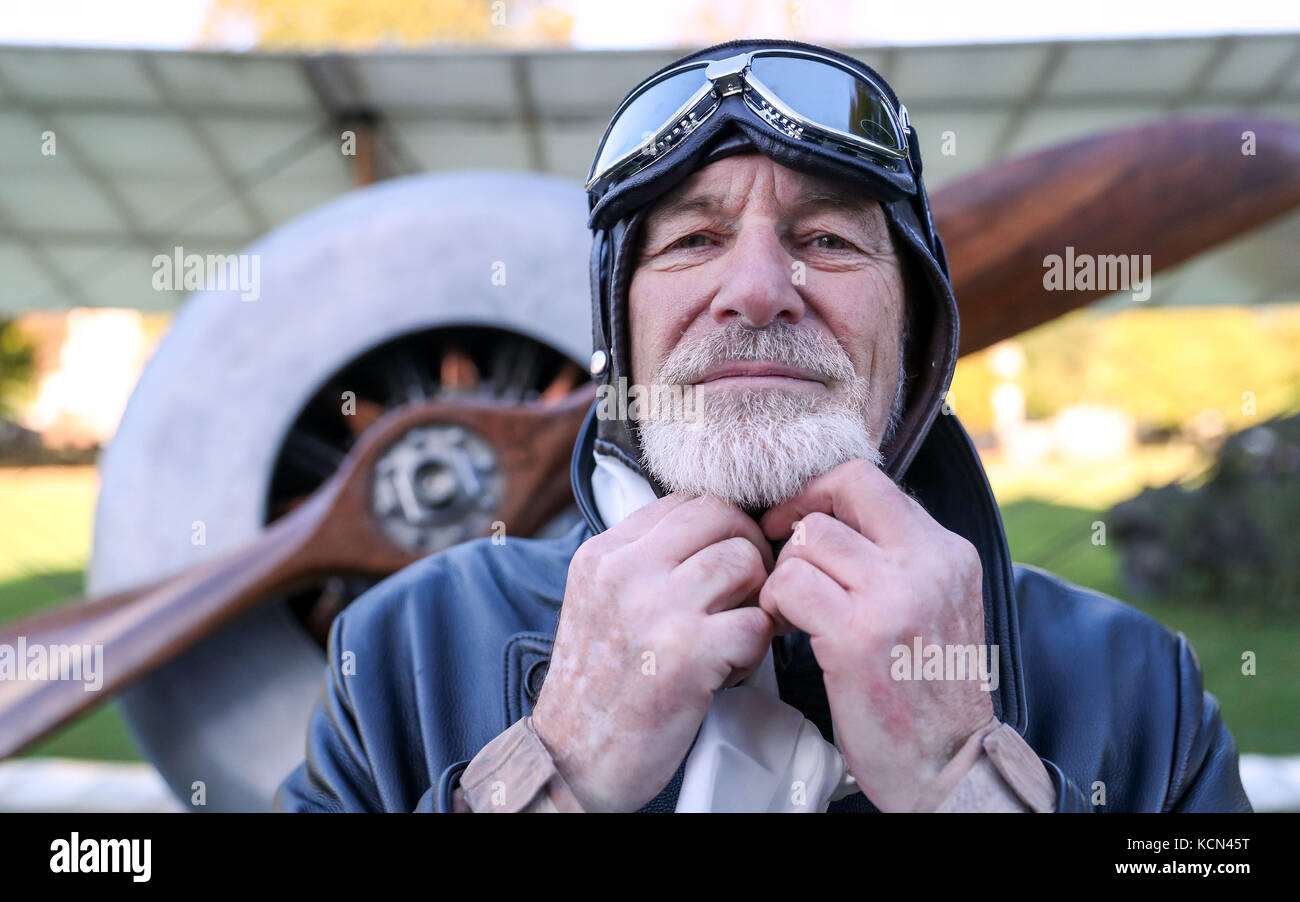 David Bremner regola il suo cappello volante mentre si trova di fronte al suo biplano Bristol Scout all'esperienza ricordata di Passchendaele alla Cattedrale di Salisbury, per celebrare il centenario della battaglia. Foto Stock