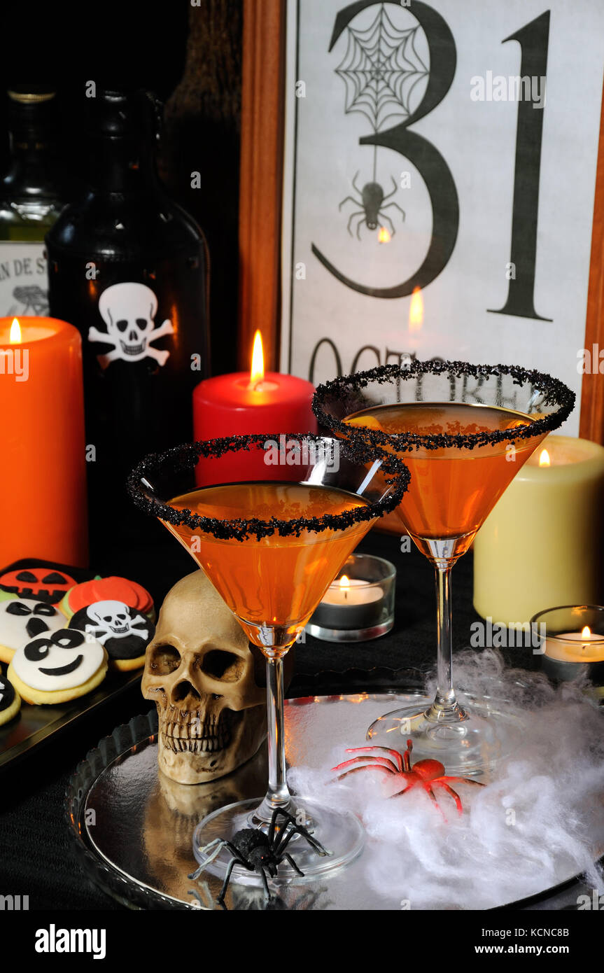 Bicchiere di citrus martini decorata con zucchero nero sul tavolo in onore di halloween Foto Stock