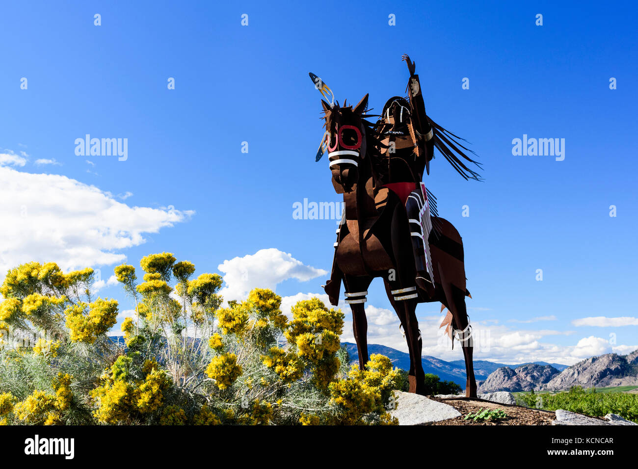 Una statua di un nativo indiano con copricapo in sella ad un cavallo in Osoyoos, British Columbia, Canada Foto Stock