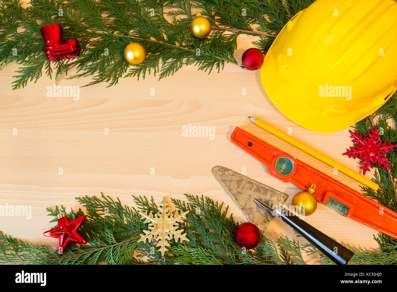 Casco di protezione, mason gli strumenti e le decorazioni di Natale su sfondo di legno Foto Stock
