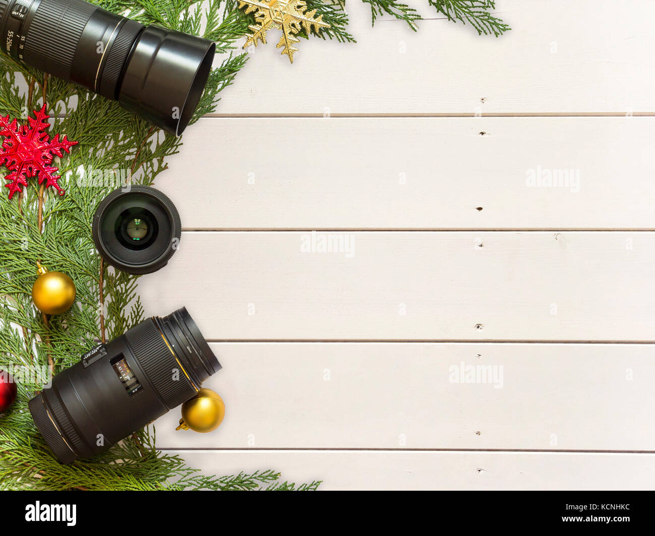 Lenti per la fotocamera reflex e decorazioni di Natale su un bianco sullo sfondo di legno Foto Stock