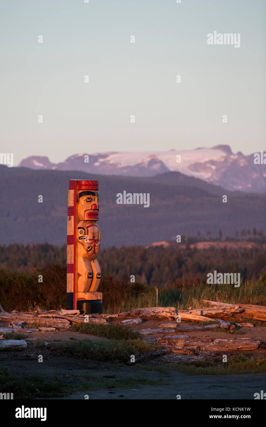Un totem pole segna l'ingresso al territorio delle prime nazioni alla fine del parco regionale Goose Spit a Comox, Vancouver Island, British Columbia, Canada Foto Stock